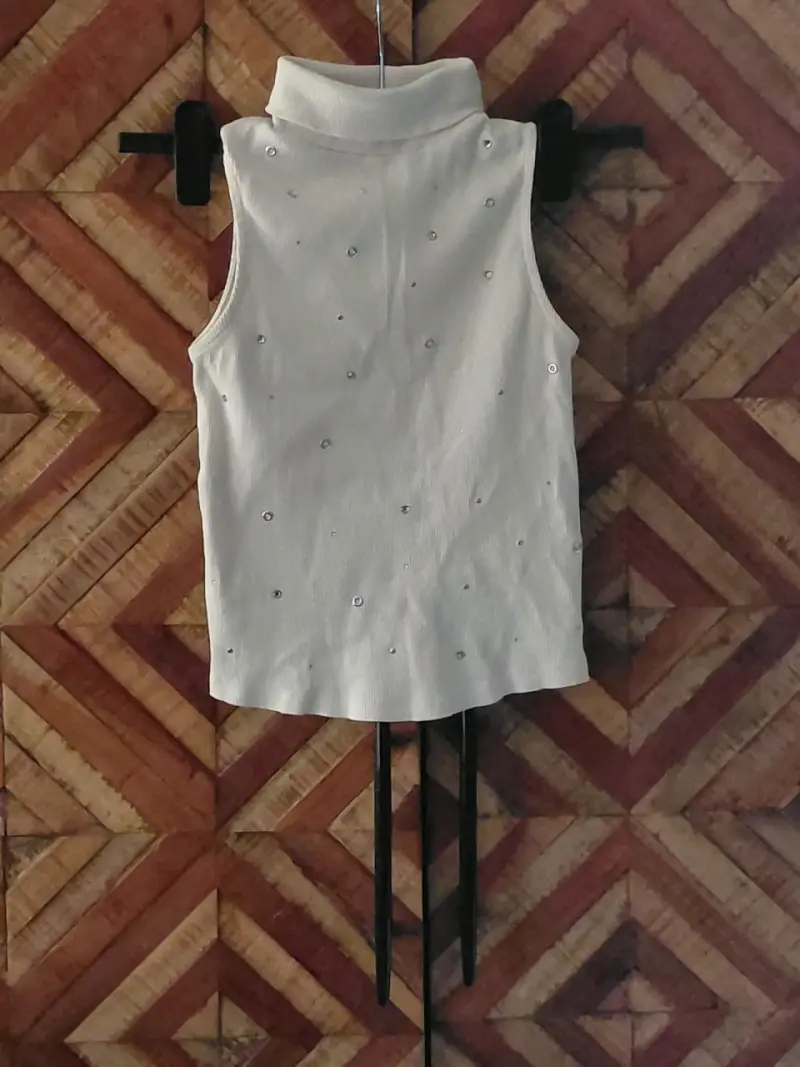 Polera sin mangas blanco con cuello alto y detalle
