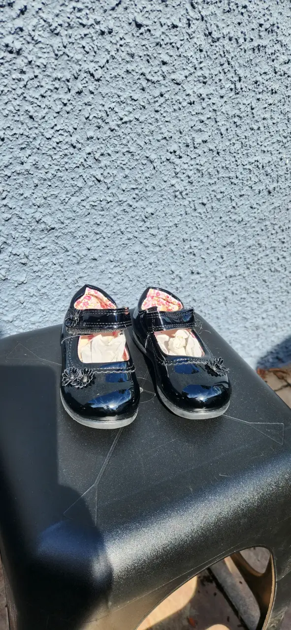 Zapatos de charol negros para niña con adorno floral