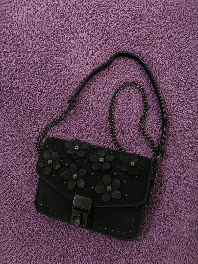 Cartera negra con diseño floral gamusa