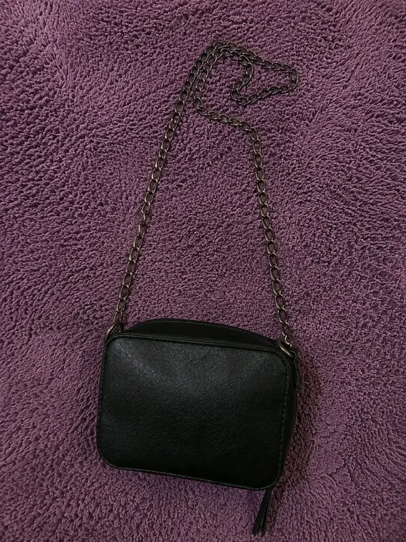 Cartera negra con cadena metálica elegante