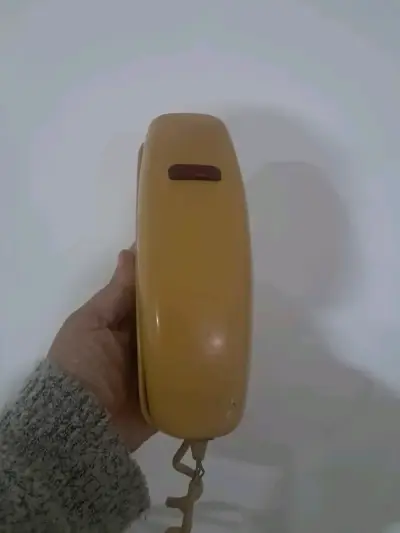 Teléfono fijo vintage amarillo con disco - miniatura 1