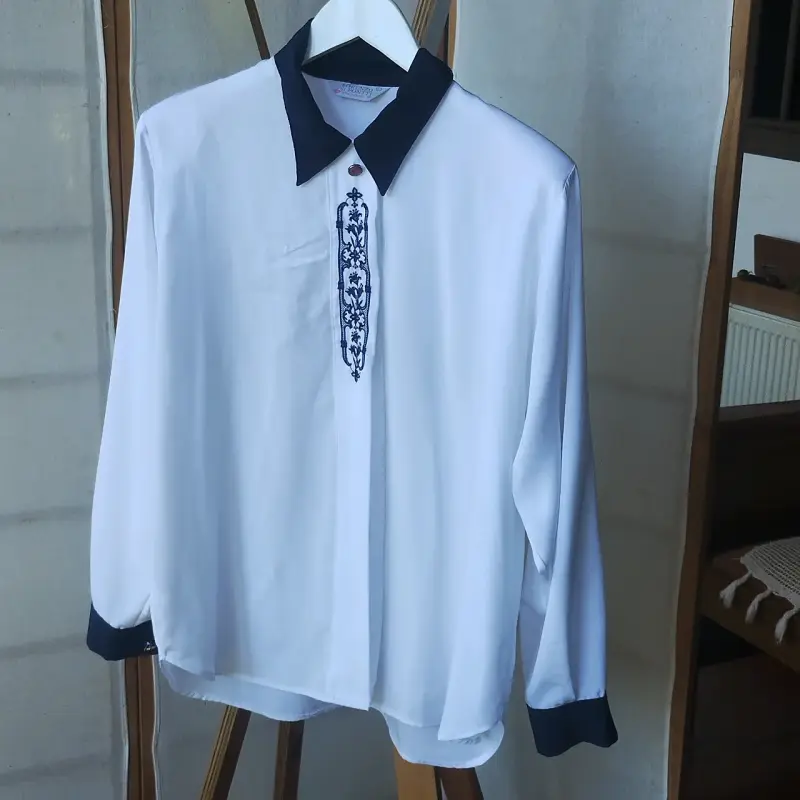 Blusa blanca con bordado azul y cuello contrastante - 1