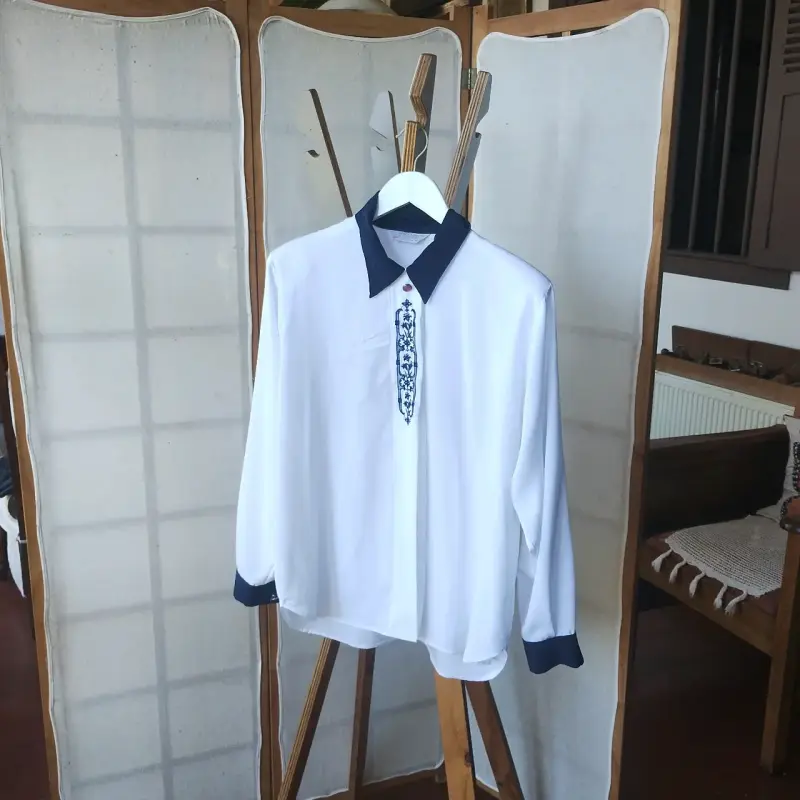Blusa blanca con bordado azul y cuello contrastante - 2
