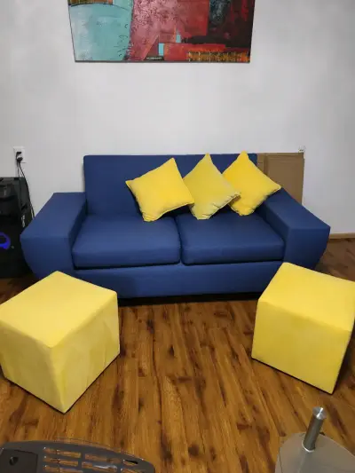 Sofá azul con cojines y pufs amarillos - miniatura 2