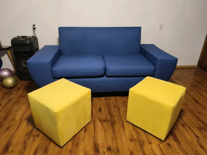 Sofá azul con cojines y pufs amarillos - 3