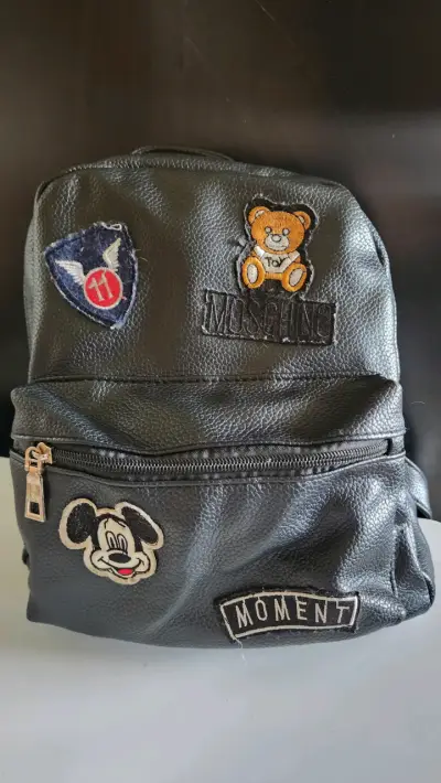 Mochila negra con parches decorativos - miniatura 1