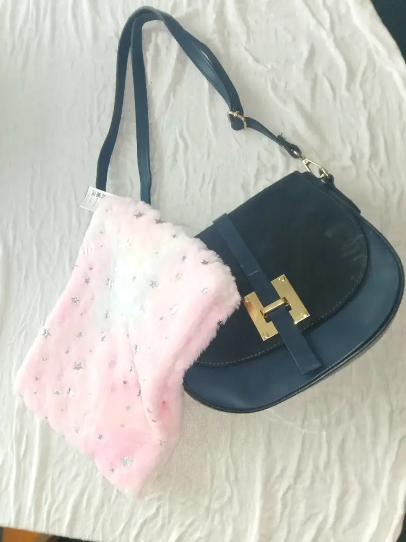 Cartera azul con detalle dorado y bolso rosa peludo