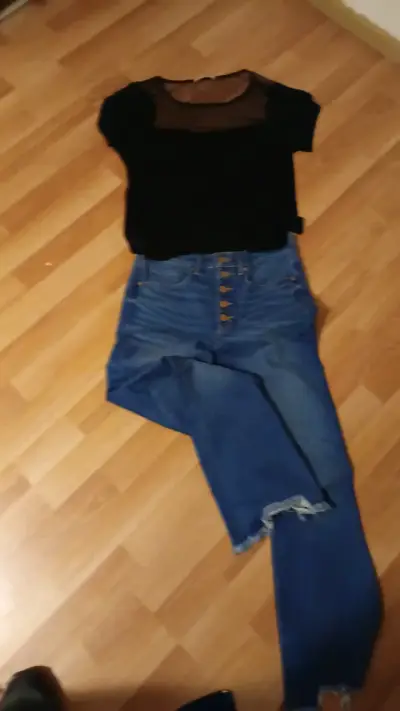 Conjunto de blusa negra y jeans azules desgastados - miniatura 1