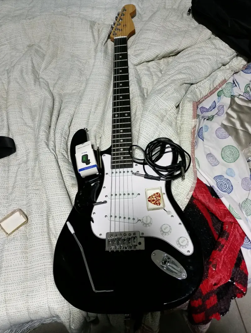 Guitarra eléctrica negra con accesorios