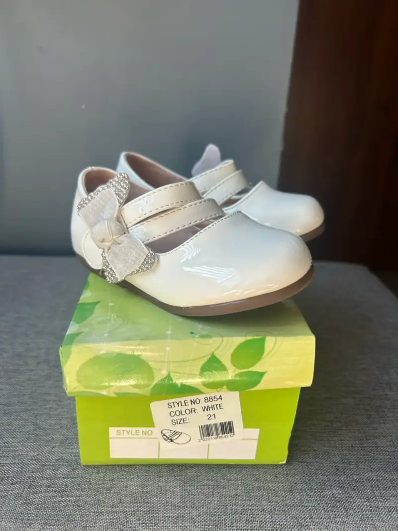 Zapatos de bebé blancos con lazo decorativo