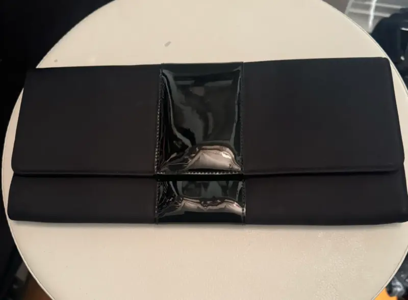 Elegante clutch negro con detalle brillante