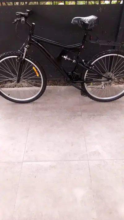 Bicicleta de montaña negra con suspensión - miniatura 1