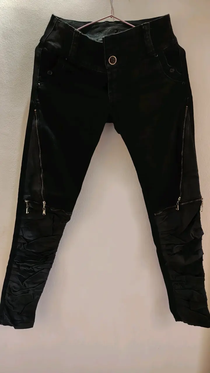 Pantalones negros con cremalleras y detalles plisados - 1