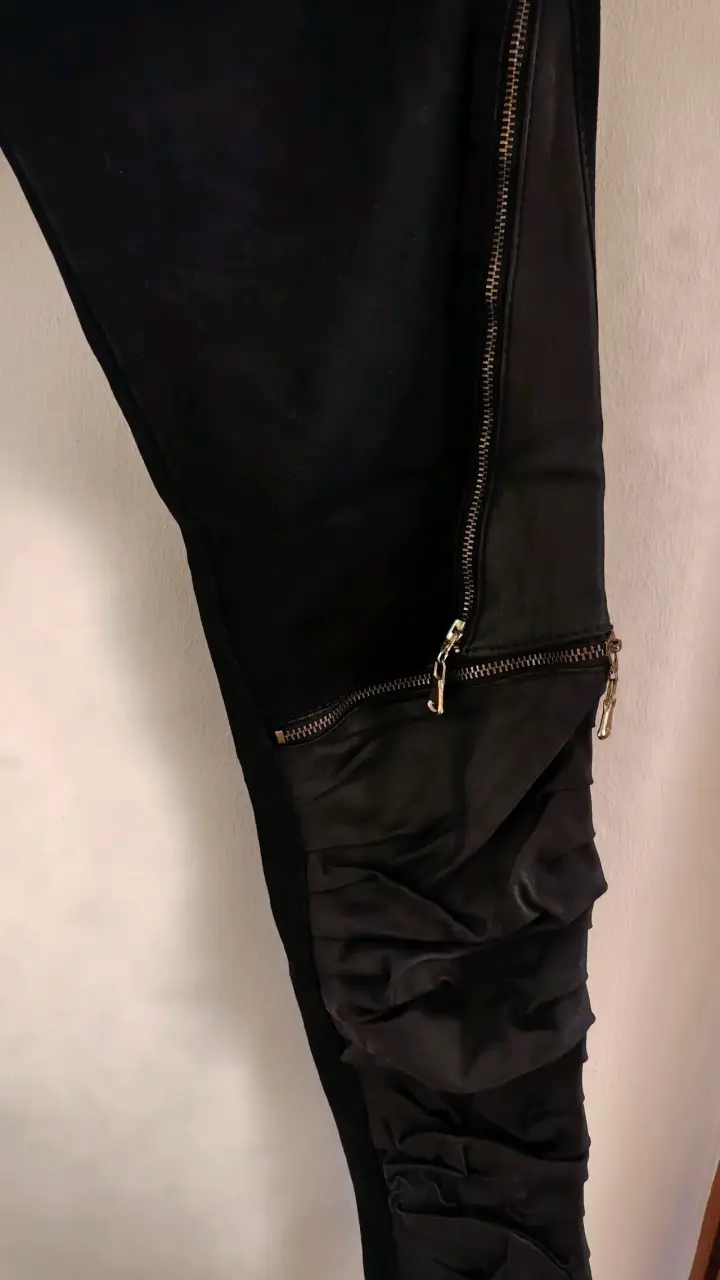 Pantalones negros con cremalleras y detalles plisados - 2
