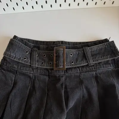 Falda corta negra con cinturón ajustable - miniatura 1