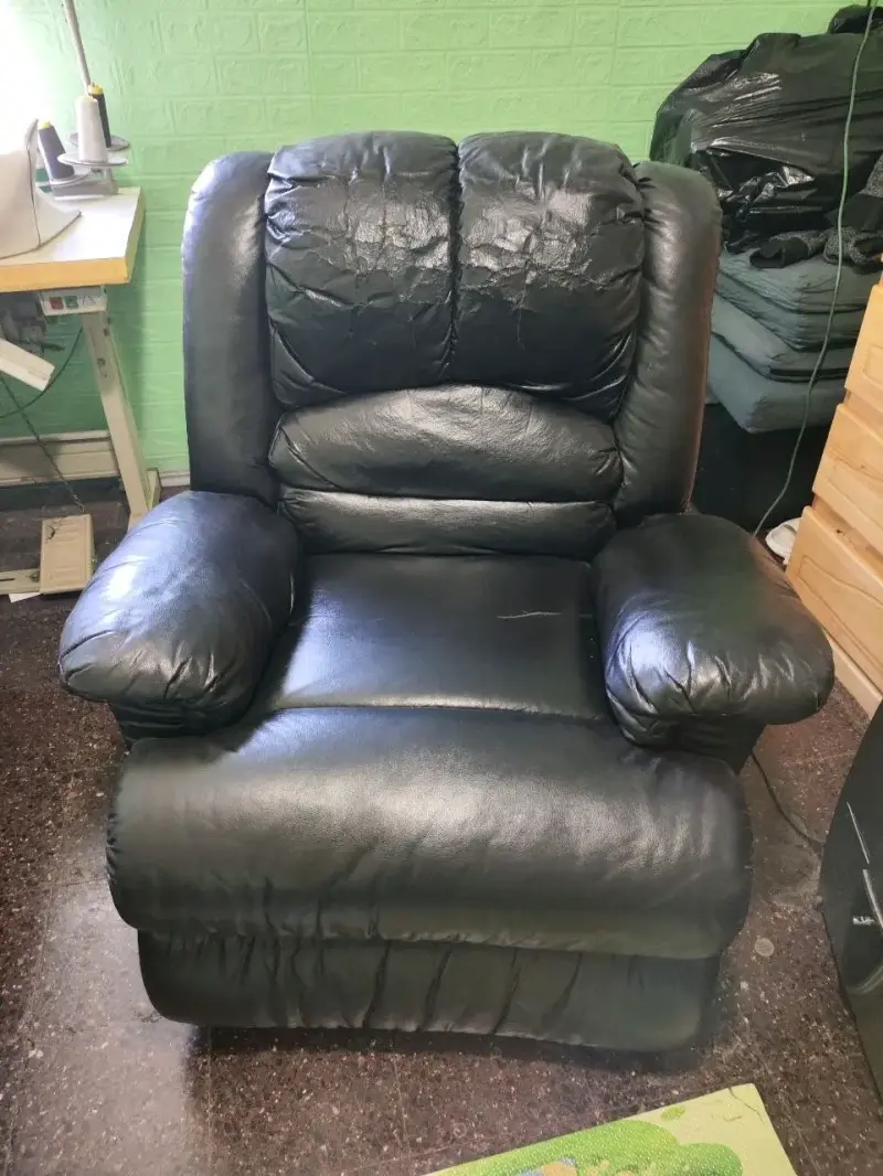 Sillón reclinable de cuero negro en buen estado