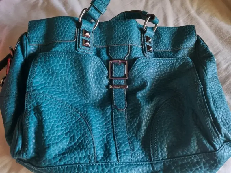 Bolso de cuero azul con hebillas decorativas