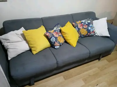 Sofá cama gris con cojines decorativos - miniatura 1