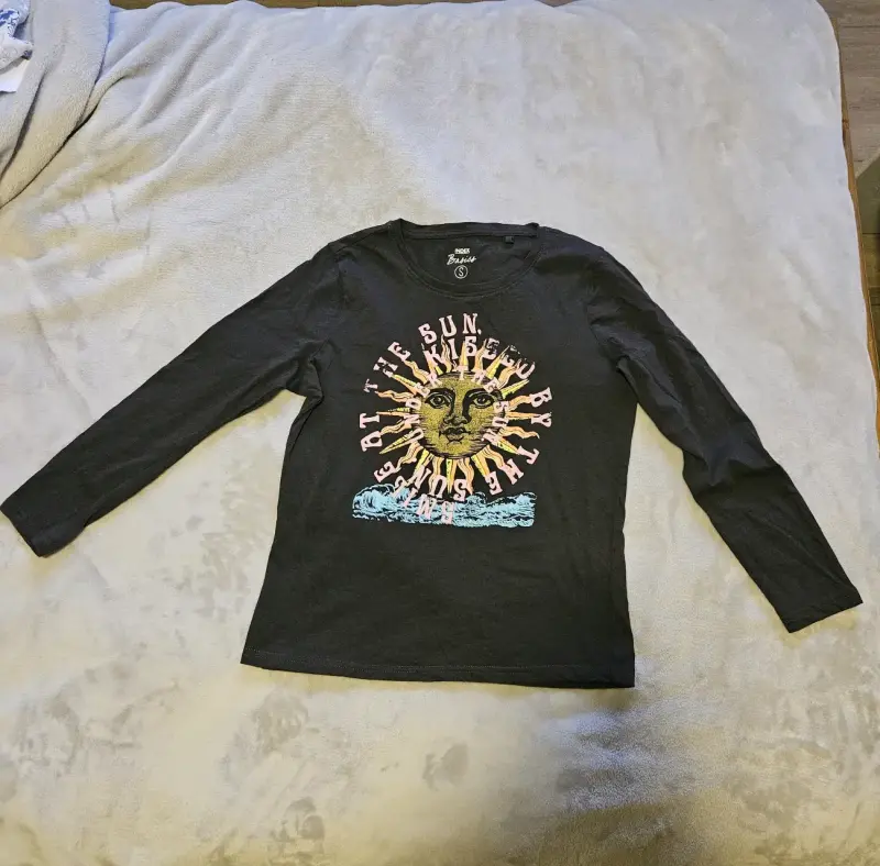 Polera manga larga negra con diseño de sol