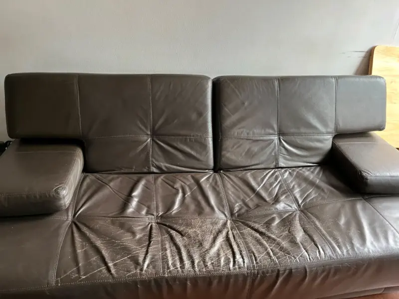 Sofá-cama de cuero marrón con desgaste visible - 1