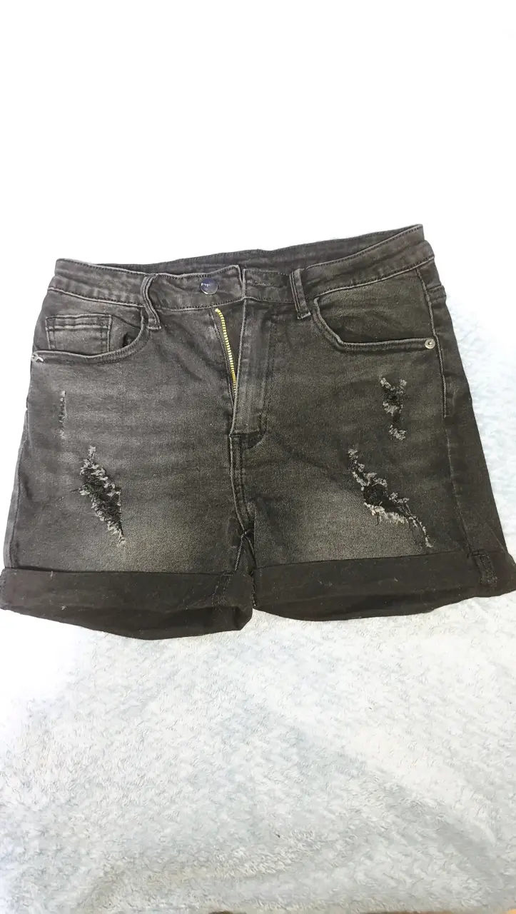 Shorts de mezclilla negros desgastados.