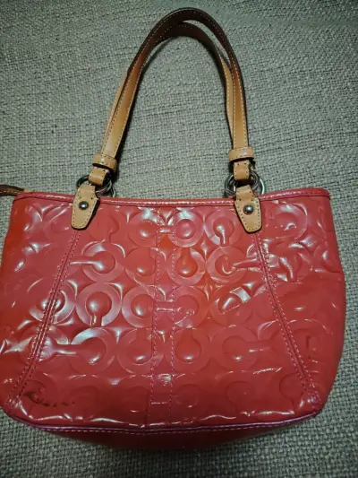 Carterita  de mano Coach rosada con diseño grabado - miniatura 1