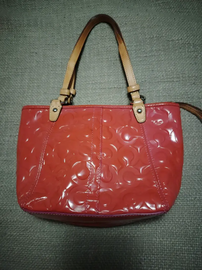 Carterita  de mano Coach rosada con diseño grabado - 2