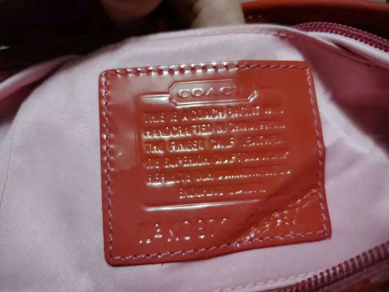 Carterita  de mano Coach rosada con diseño grabado - 4