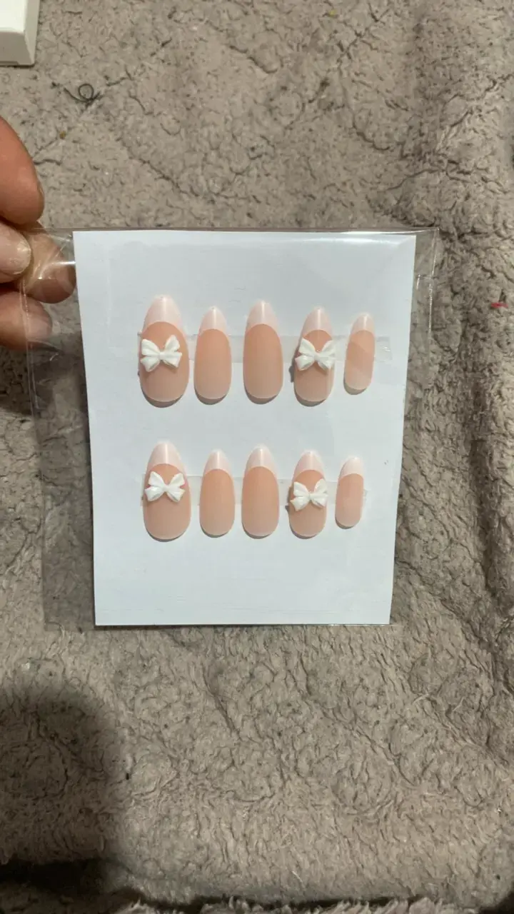 Uñas postizas nude con lazo decorativo