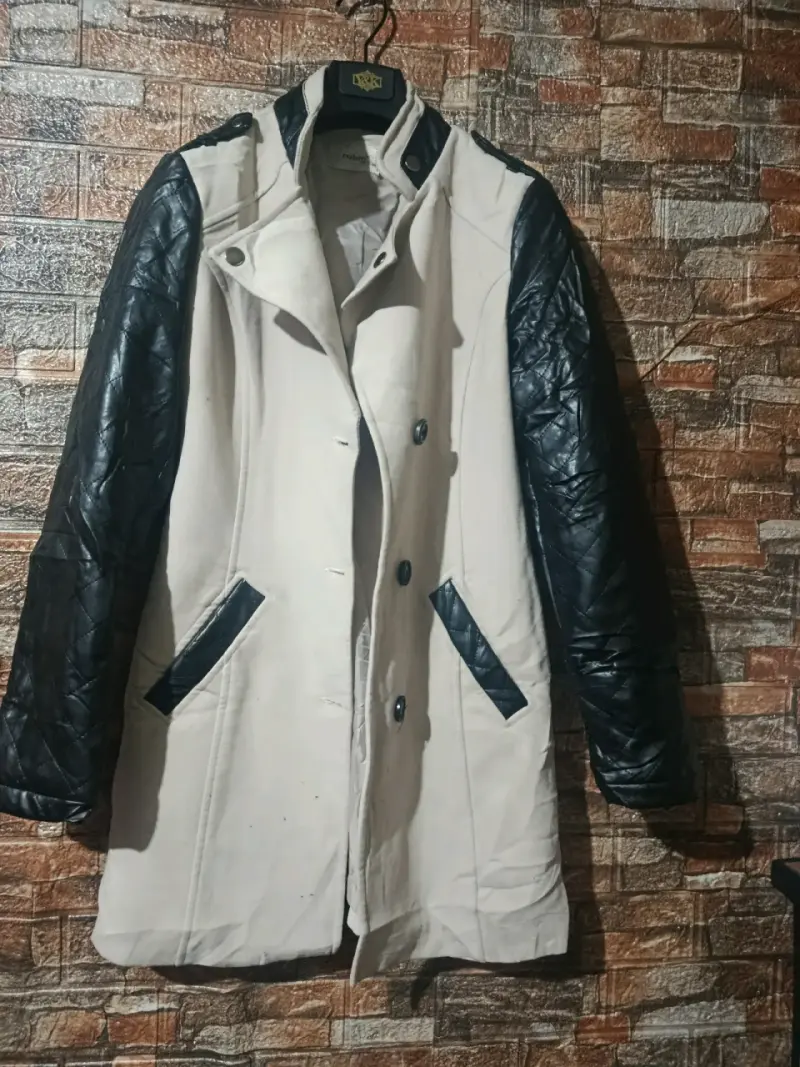 Abrigo beige con mangas negras acolchadas