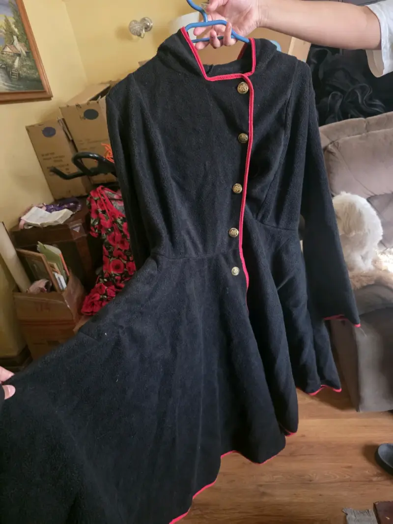 Vestido negro con ribetes rojos y botones dorados
