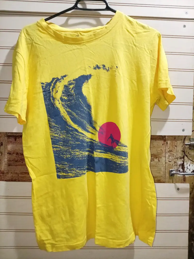 Polera amarilla con diseño de surfista