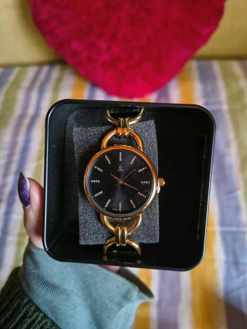 Reloj de muñeca dorado con esfera negra y cristale