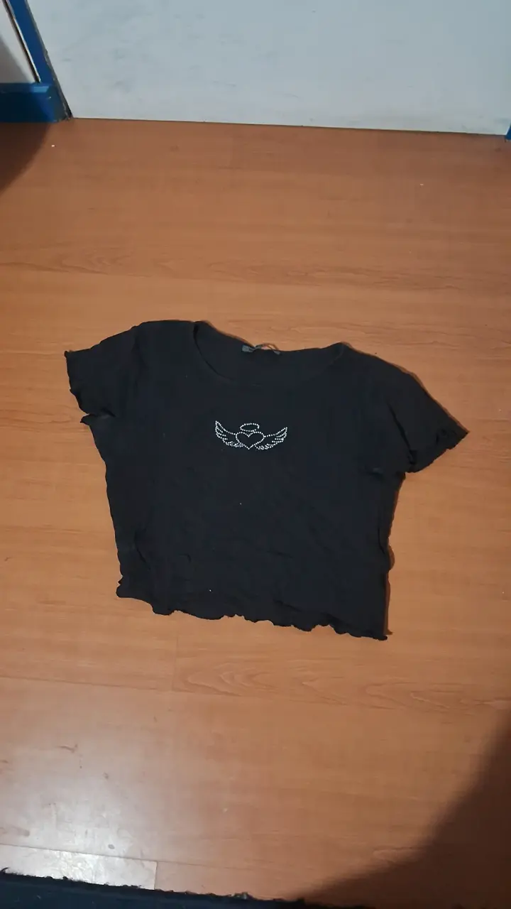 Polera negra con diseño de alas y corazón