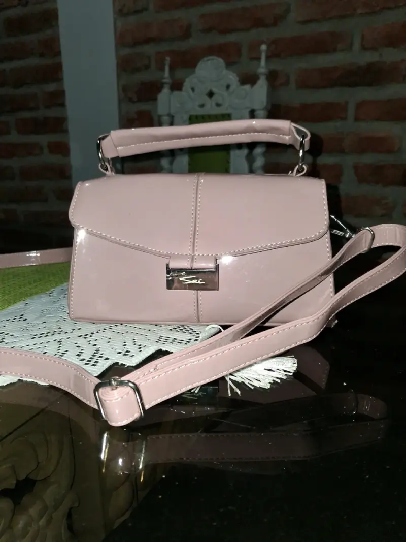 Cartera de mano rosa con correa ajustable