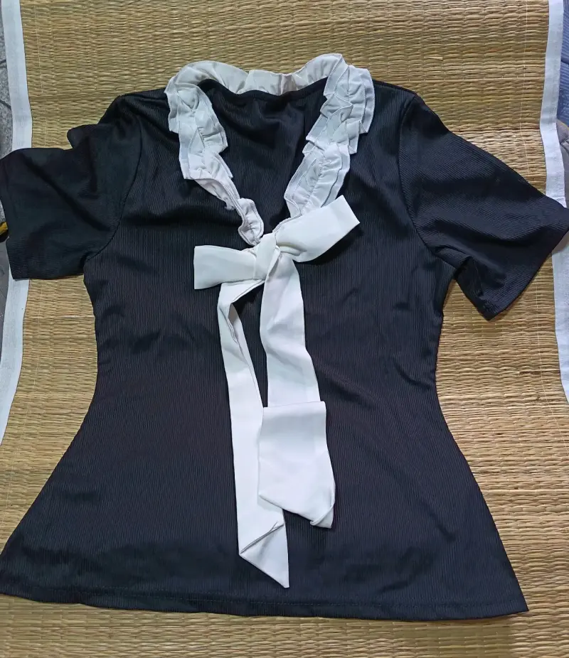 Blusa negra con lazo blanco elegante