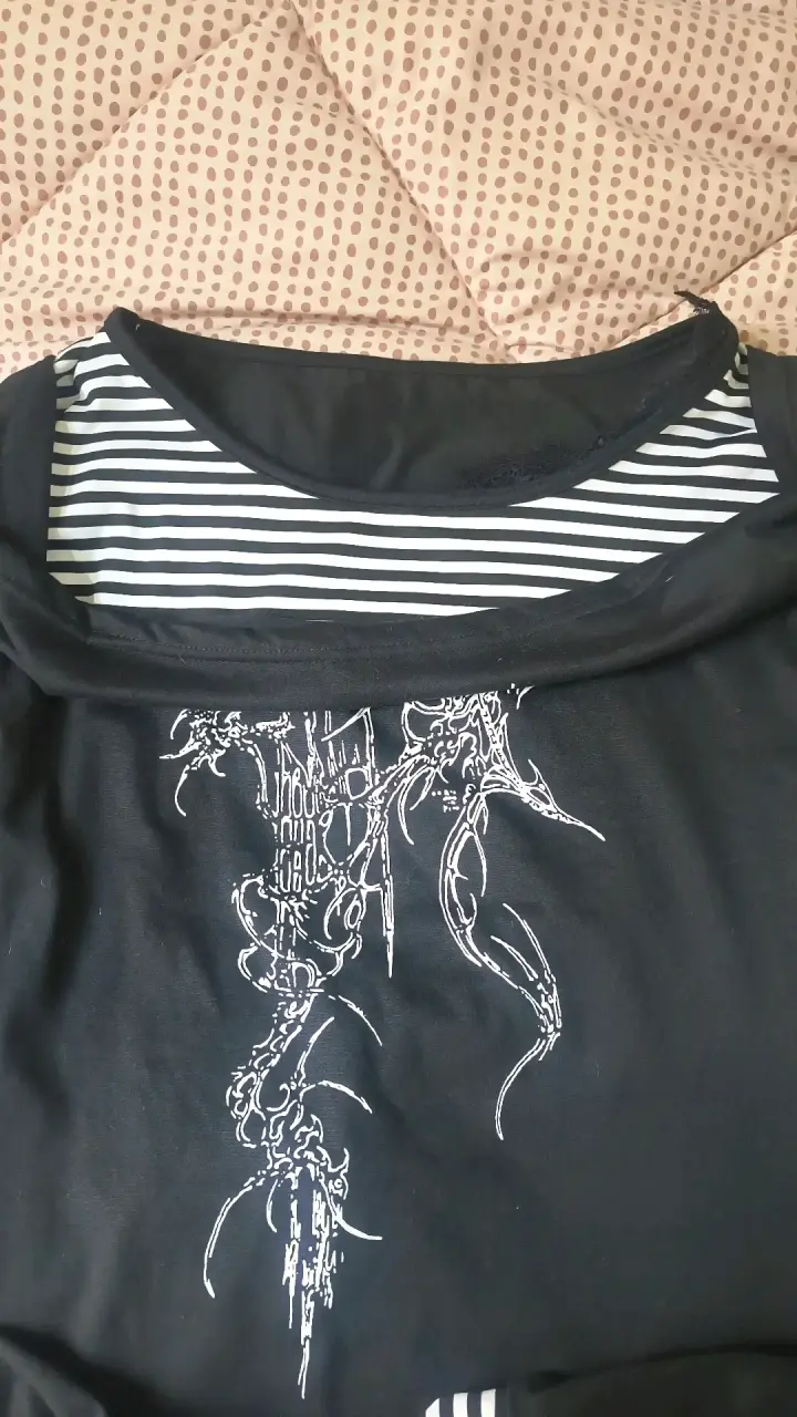Polera negra con diseño gráfico y rayas - 2