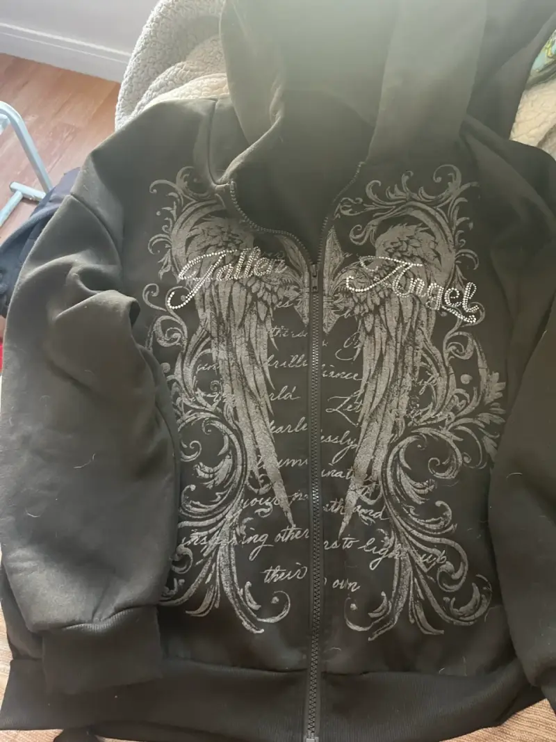 Polerón negro con diseño de alas y capucha