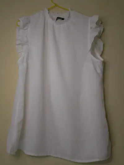 Blusa blanca sin mangas con volantes - miniatura 1