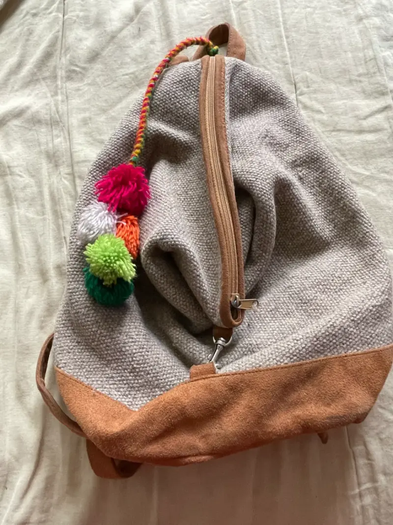Mochila de tela con pompones coloridos