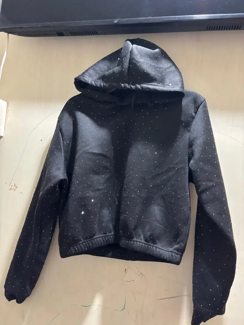 Polerón negro con capucha y diseño de puntos