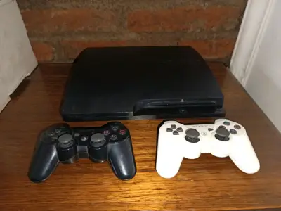 Consola PlayStation 3 con dos controles y juegos - miniatura 1