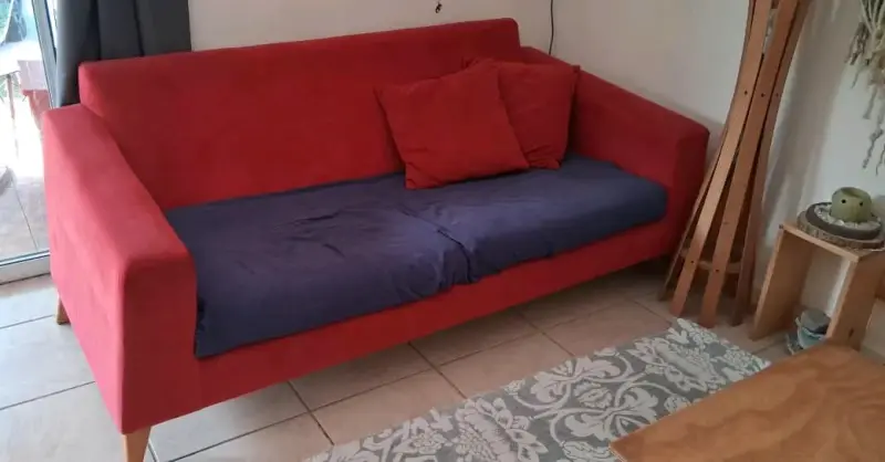 Sofá rojo de tela con cojines