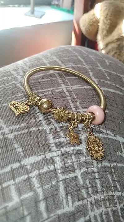 Pulsera dorada con dijes decorativos - miniatura 1