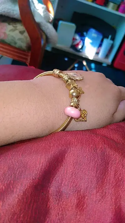 Pulsera dorada con dijes decorativos - miniatura 2
