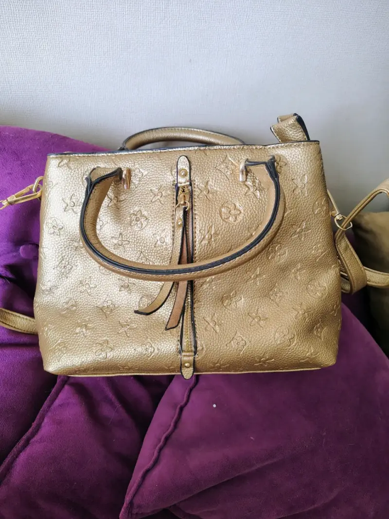Bolso de mano dorado con diseño floral