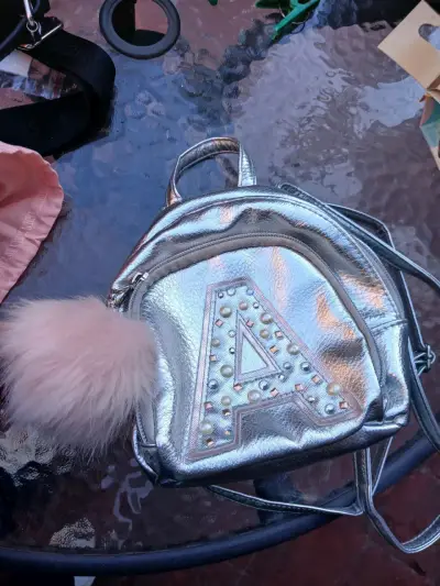Mochila pequeña plateada con pompón marca Justice - miniatura 2