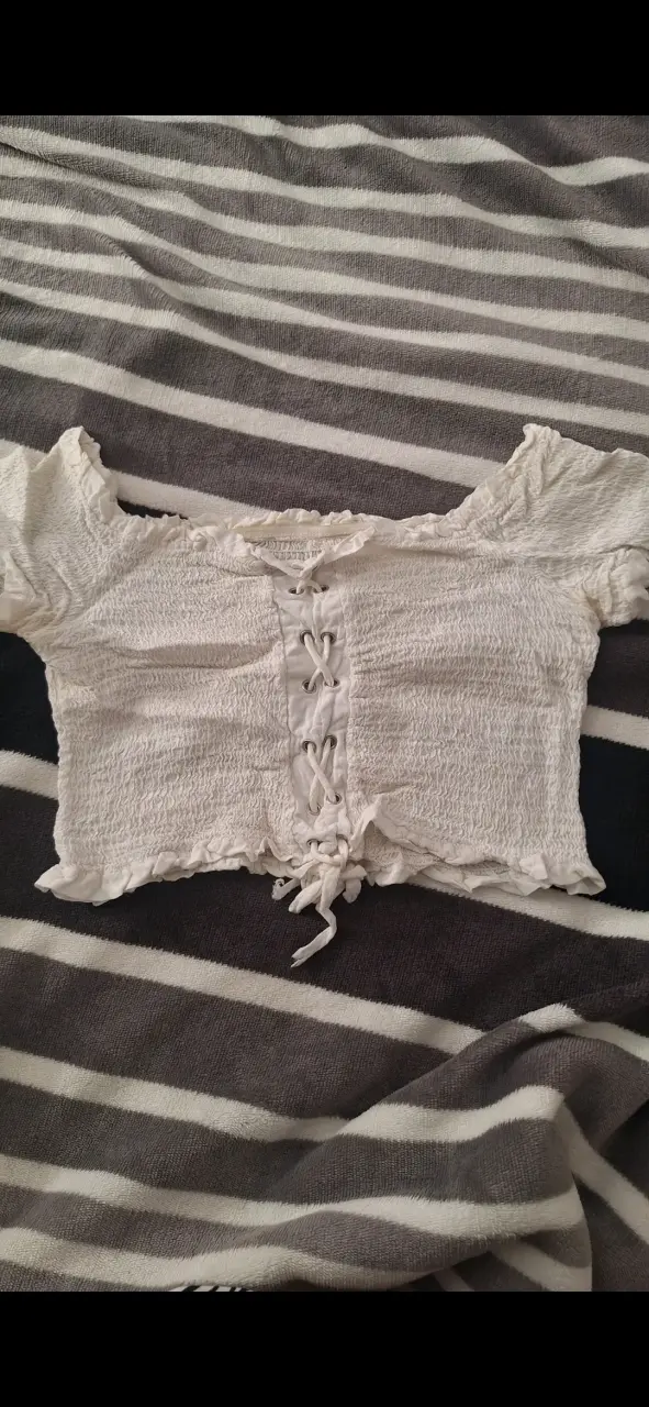 Top blanco con diseño fruncido y cordones