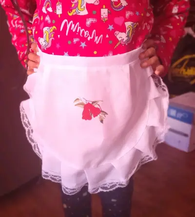 Delantal infantil blanco con bordado de flor - miniatura 1