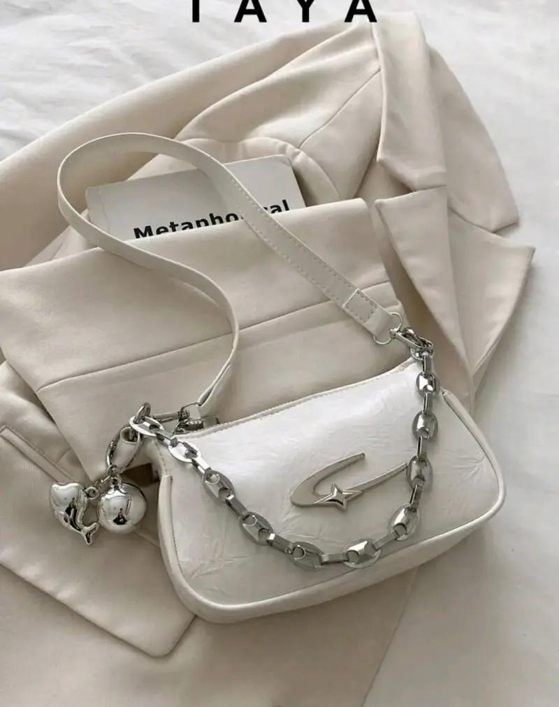 Cartera blanca con cadena metálica decorativa